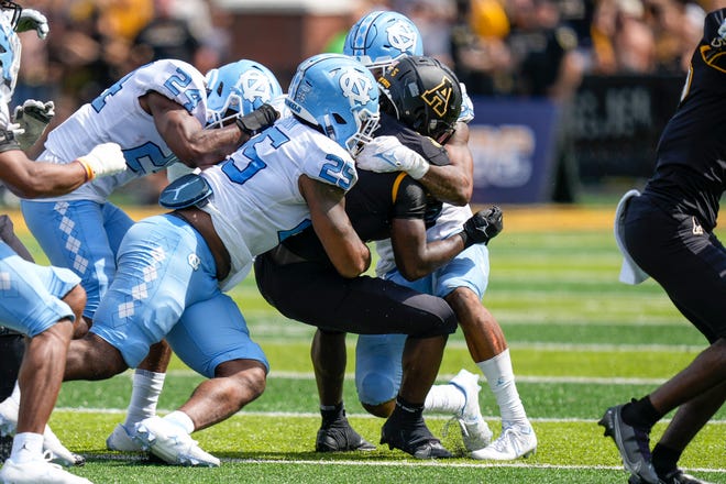 September 3, 2022;  Boone, North Carolina, United States;  Appalachian State Mountaineers running back Nate Noel (5) is mobbed by UNC defenders during the second half at Kidd Brewer Stadium.