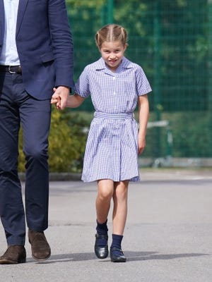 Princess Charlotte arrives with her father Prince William, left, at Lambrook School, her new school in Berkshire near the Windsor Castle estate, on Sept. 7, 2022, the day before classes begin. Dressed in a light blue, checkered short-sleeve dress, the princess showed that even academia can be colorful.