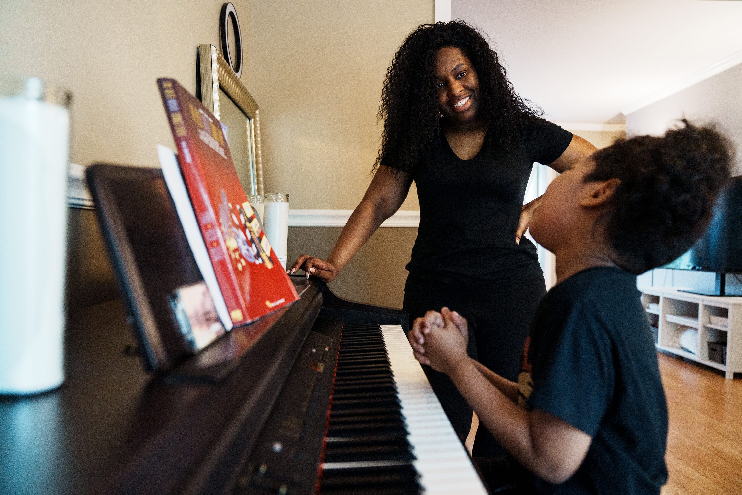Cynthia Adinig listens as her son Aiden explains piano playing techniques at their Vienna, Virginia, home on Sept. 7.