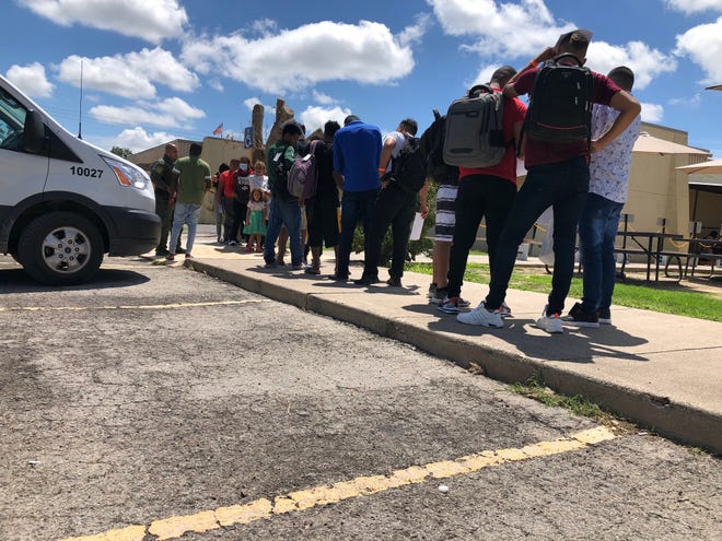 Migrants line up outside the Val Verde Border Humanitarian Union shelter in Del Rio, Texas, after being released by the US Border Patrol.  Many of the migrants would then take state-sponsored buses to Washington, New York or Chicago.