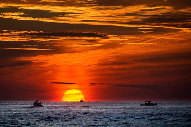 لابسٹر ماہی گیر پہلے سے ہی کام پر ہیں جب سورج بحر اوقیانوس پر طلوع ہوتا ہے، جمعرات، 8 ستمبر، 2022 کو، کینی بنکپورٹ، مین سے دور۔