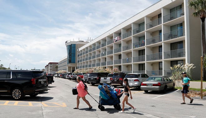 Beachgoers pull a wagon loaded with chairs across the 14th Street parking lot on Tybee Island.
