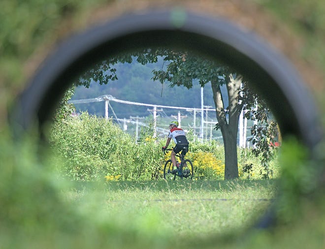 A cyclist passes  the new dog park known as Finnigan's Run near the Richland B&O Bike trail off of Ohio 97 in Bellville on Thursday.