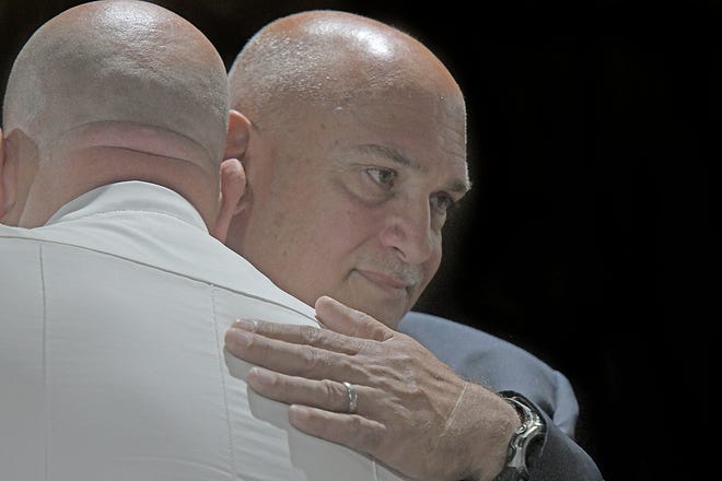 Detective David Scheurer and Mansfield Police chief Keith Porch share a hug Thursday afternoon during Scheurer's retirement celebration.