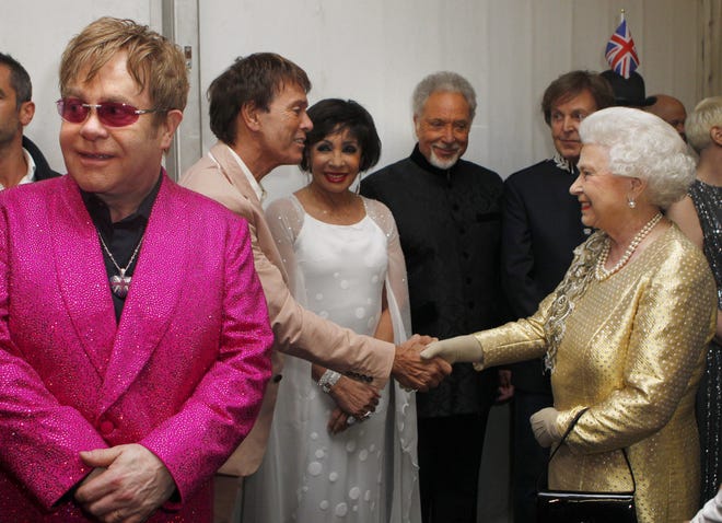 Queen Elizabeth II greets Sir Cliff Richard backstage as British singer Elton John (left) looks on during the Diamond Jubilee Concert outside Buckingham Palace in London on June 4, 2011.