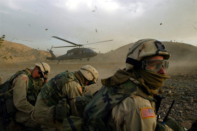 Members of the 82nd Airborne duck as a Blackhawk helicopter prepares to withdraw troops in southeastern Afghanistan in 2002.