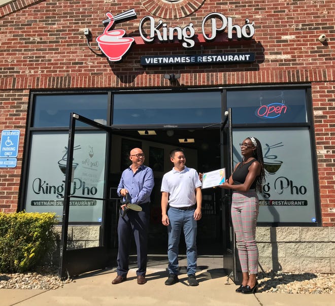 King Pho co-owners Phillip Nguyen and Thai Nguyen are presented with a new business certificate by Meridian Township Neighborhoods and Economic Development  Director Amber Clark during a ribbon-cutting ceremony Sept. 9, 2022.