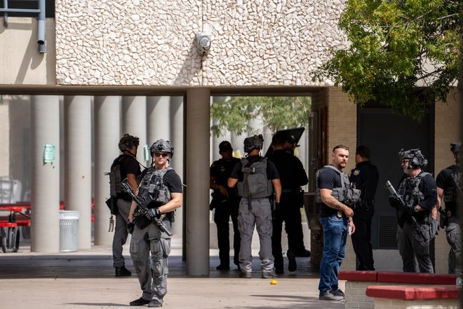 Police officers gather at Central High School after the campus was placed on lockdown in Phoenix on Sept. 9, 2022.