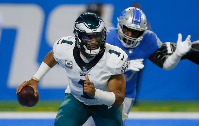 Philadelphia Eagles quarterback Jalen Hurts (1) is is pursued by Detroit Lions outside linebacker Charles Harris (53) during the first half of an NFL football game, Sunday, Oct. 31, 2021, in Detroit.