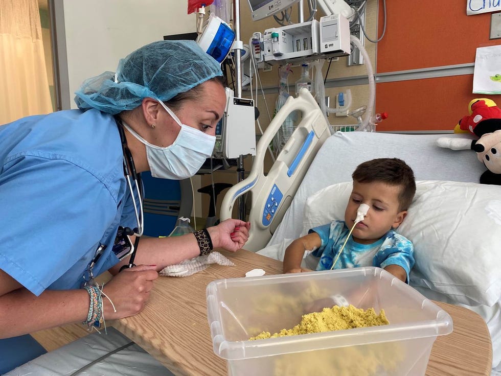 Stony Brook Medicine nurse practitioner Krista O’Donnell with Charlie DeFraia, 4,  as he plays with sand to regain use and strength of his hand and arm.