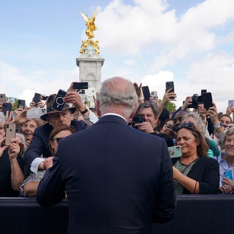 Britain's King Charles III, back to the camera, gr