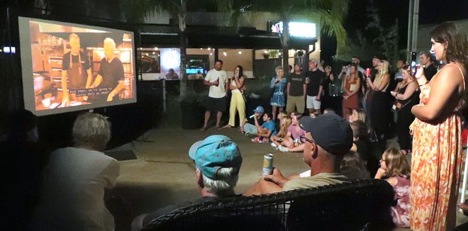 A crowd gathers around a large TV in the parking lot of Panheads Pizzeria in New Smyrna Beach on Friday to watch Guy Fieri's "Diners, Drive-Ins and Dives." The restaurant was featured in Friday's episode of the popular Food Network show.