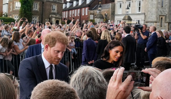 Pangeran Inggris Harry dan Meghan, Duchess of Sussex bertemu orang-orang setelah melihat upeti bunga untuk mendiang Ratu Elizabeth II di luar Kastil Windsor, di Windsor, Inggris, Sabtu, 10 September 2022.