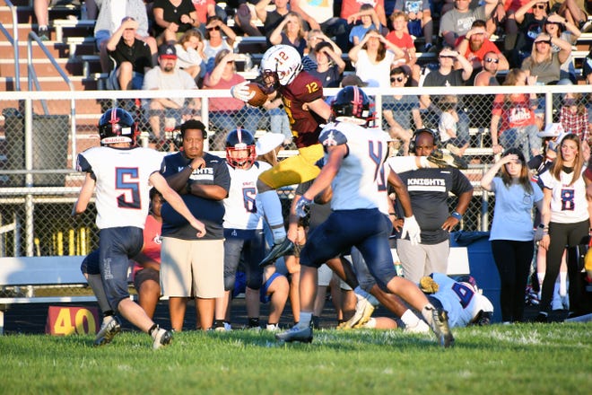Berne Union senior quarterback, shown leaping over a Fairfield Christian Academy defender, has rushed for for a combined 675 yards and 10 touchdowns the last three weeks and helped lead the Rockets to three straight wins.