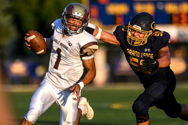 Holt's Seneca Moore, left, runs for a gain as Grand Ledge's Ryan Beattie closes in during the second quarter on Friday, Sept. 9, 2022, at Grand Ledge High School.