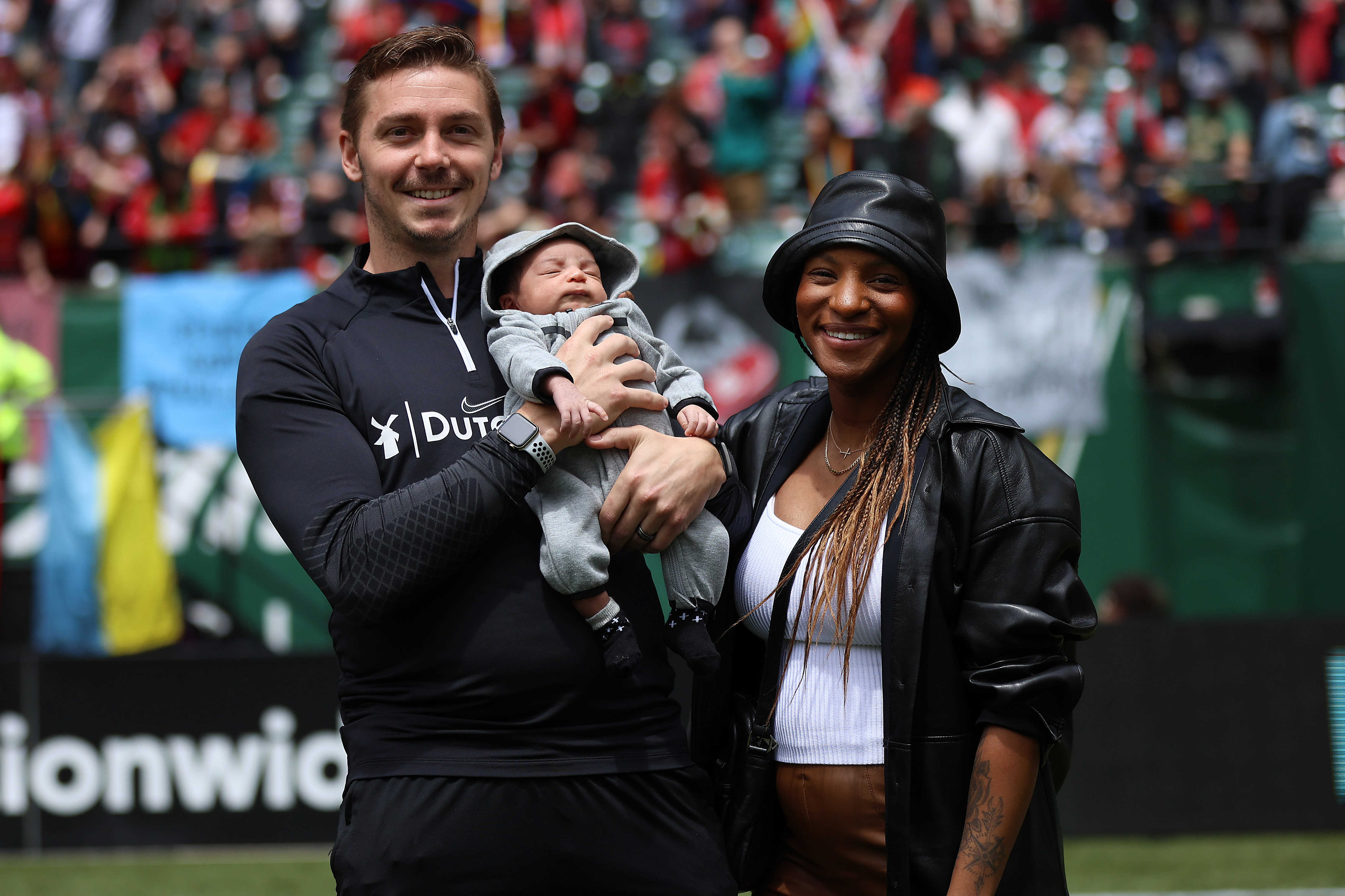 Portland Thorns FC player Crystal Dunn poses for a photo with husband Pierre Soubrier and their son Marcel Jean at Providence Park on June 19, 2022.