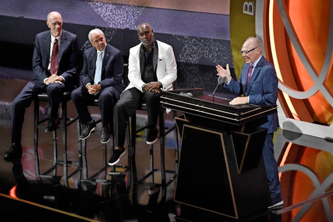 George Karl speaks during his enshrinement at the Basketball Hall of Fame as presenters, from left, Bobby Jones, Roy Williams and Gary Payton, listen Saturday in Springfield, Mass.