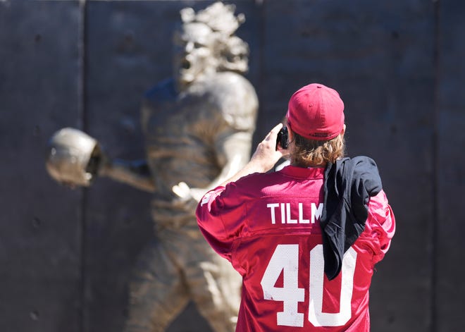 Jimbo McAllister takes a picture of the Pat Tillman memorial statue outside State Farm Stadium before NFL action between the Arizona Cardinals and the Kansas City Chiefs on Sept. 11, 2022. Tillman left the Cardinals and enlisted in the United States Army in May 2002 in the aftermath of the September 11 attacks and died in Afghanistan in 2004.