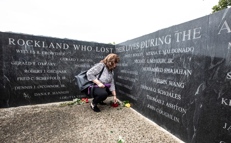 Laurie Weinberg of New City leaves flowers near the name of her husband Steven Weinberg at the Rockland County Sept.11 Memorial in Haverstraw after the county held its annual 9/11 memorial service Sept. 11, 2022. Steven Weinberg was among the Rockland County residents who died in the Sept. 11 attack on the World Trade Center.    