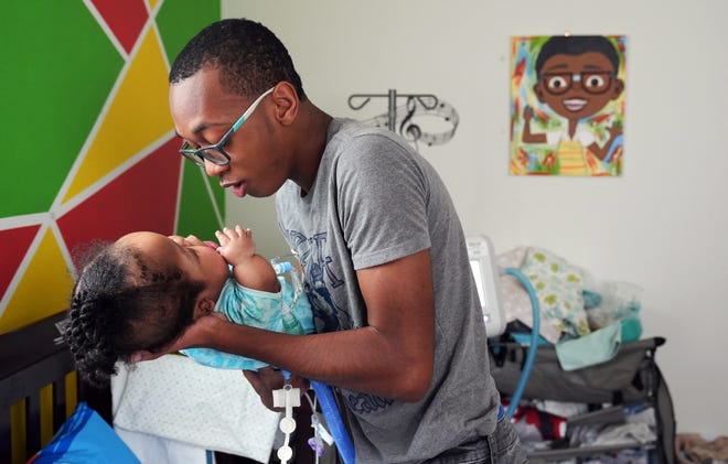 Ameir Lacey, 12, holds his brother Jakobi Bays, 3, who was diagnosed with thanatophoric skeletal dysplasia, a rare form of dwarfism, before birth.  Both are the subjects of the book