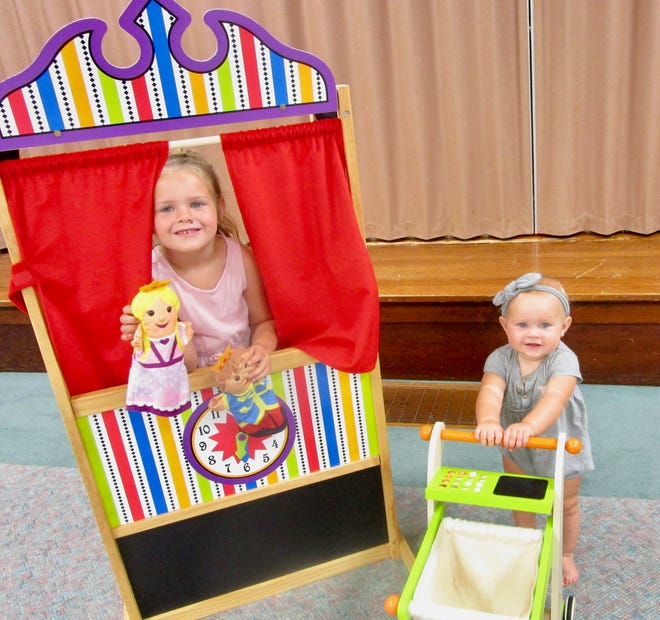 Claire Rushing, left, and her younger sister Sophie show off some of the toys to be used for the Lil’ GUMDROPS (Grace United Methodist Church Draw, Read, Open Play and Snack) playgroup offered in Geneseo beginning Wednesday, Sept. 21. The girls are the daughters of Robbie and Jenna Rushing.