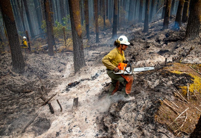 Sawyer Brock Marquez with the Lakeview hotshots works to secure a fire line on the Cedar Creek Fire east of Oakridge.