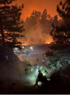 In this handout photo obtained from the San Francisco Fire Department on September 11, 2022, firefighters from the San Francisco Fire Department work to extinguish flames from the Mosquito Fire, outside Sacramento, California .