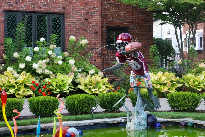 Dubbed the "Famous Frog" by neighbors along Beaver's River Road, the colorfully dressed statue has taken on a new apperance this football season to support the Beaver Bobcats. The frog is sporting a vintage team jersey with the number 88, which was the jersey number of the house's former resident.