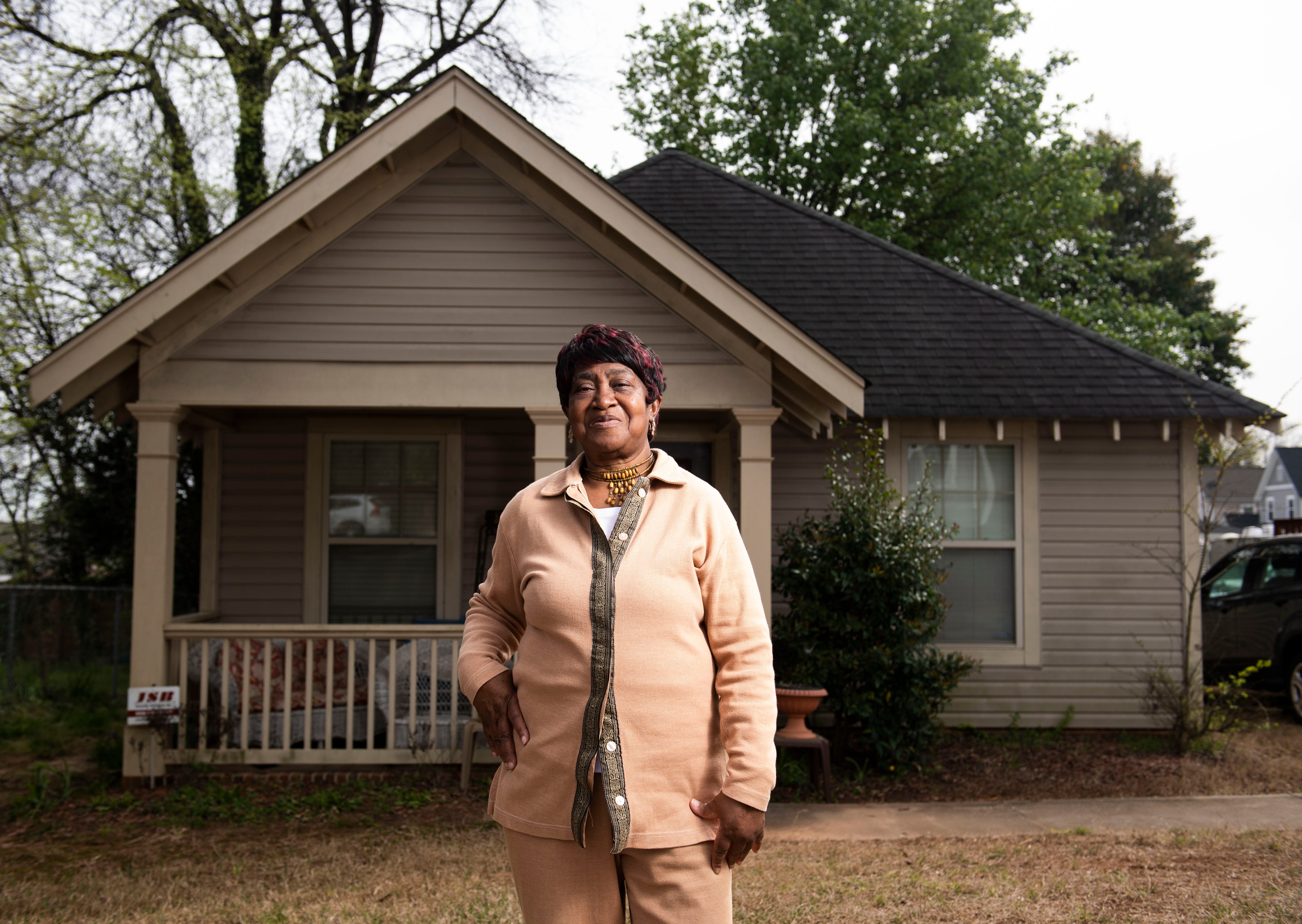 Shirley Gambrell stands in front of her home