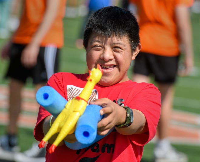 Metamora freshman Angel Vasquez has a laugh as he balances a rubber chicken during the rubber chicken relay race Wednesday, Sept. 15, 022 at the Mid-Illini Unified PE Field Day on Babcook Field in Washington.