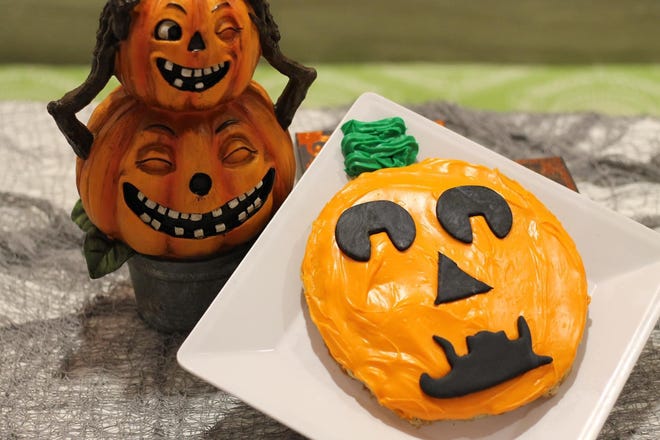 The Jack O Lantern Stack is a stack of pumpkin pancakes topped with orange colored cream cheese icing and decorated with a fondant face.