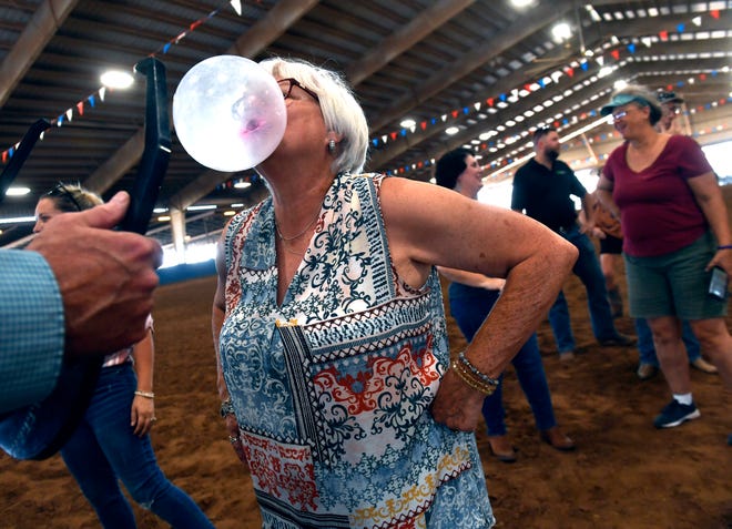 Pam Welborn blows a bubble for a judge during Tuesday's Bubble Gum Contest at the West Texas Fair & Rodeo. Fifty contestants participated in the fair contest, which was followed by a sack races, egg-tossing, and other games for kids.