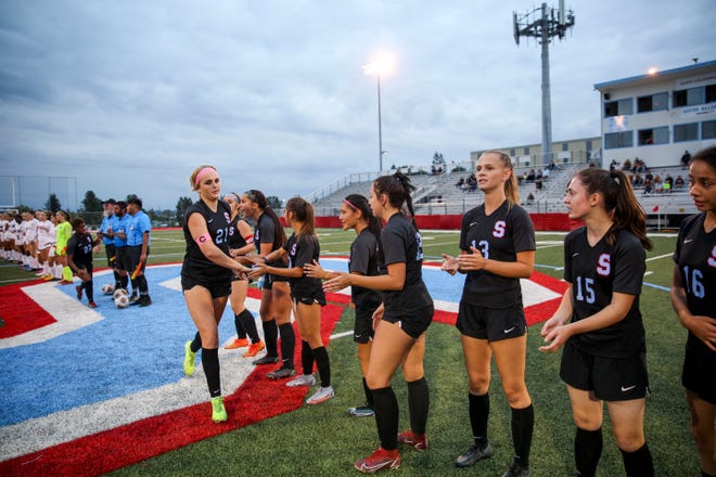 South Salem's Mya Fry (21) high fives her teammates after she's introduced before the South Salem game against Tigard on Tuesday, Sept. 13, 2022 in Salem, Ore.
