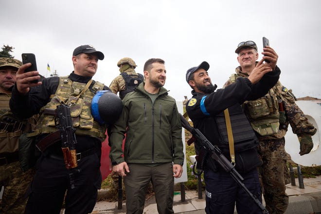 This handout picture taken and released by Ukrainian Presidential press service on Sept. 14, 2022, shows Ukrainian president Volodymyr Zelensky, center, posing with servicemen in the de-occupied city of Izyum, Kharkiv region.