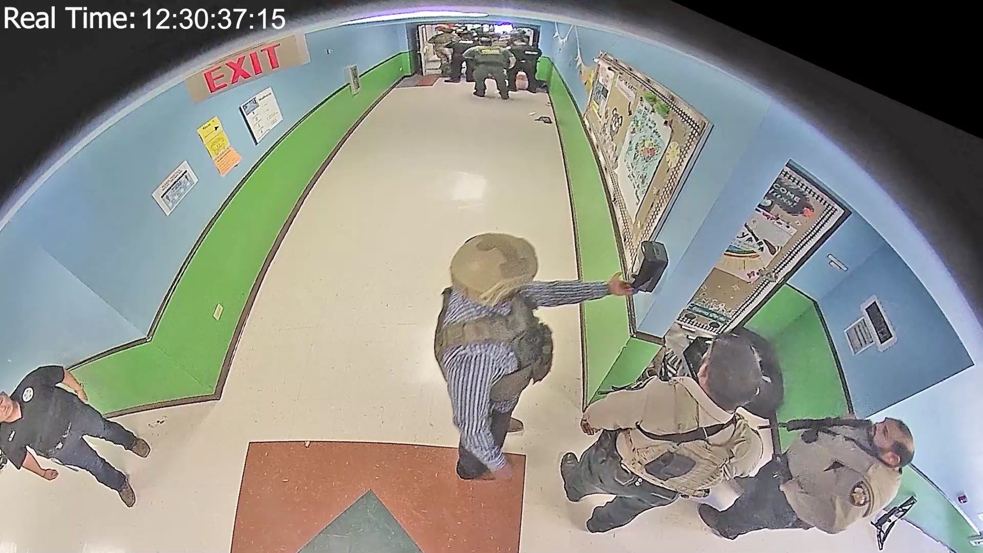 A law enforcement officer uses a hand sanitizer dispenser in the hallway at Robb Elementary in Uvalde, Texas on May 24, 2022.