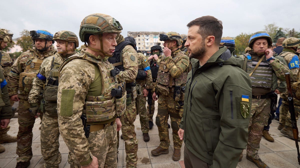 Ukrainian President Volodymyr Zelenskyy, right, listens to Gen. Oleksandr Syrskyi's report during his visit in Izium, Kharkiv region, Ukraine, Wednesday, Sept. 14, 2022. Ukrainian troops piled pressure on retreating Russian forces Tuesday, pressing deeper into occupied territory and sending more Kremlin troops fleeing ahead of the counteroffensive that has inflicted a stunning blow on Moscow's military prestige.