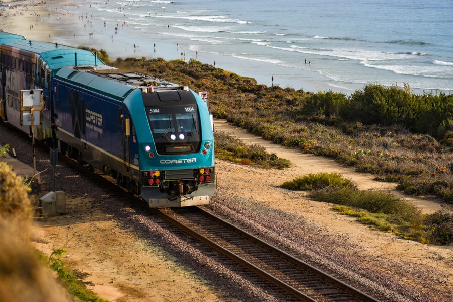 A train travels along coastal tracks in San Diego County with Torrey Pines State Beach in the background on Sept. 11, 2022