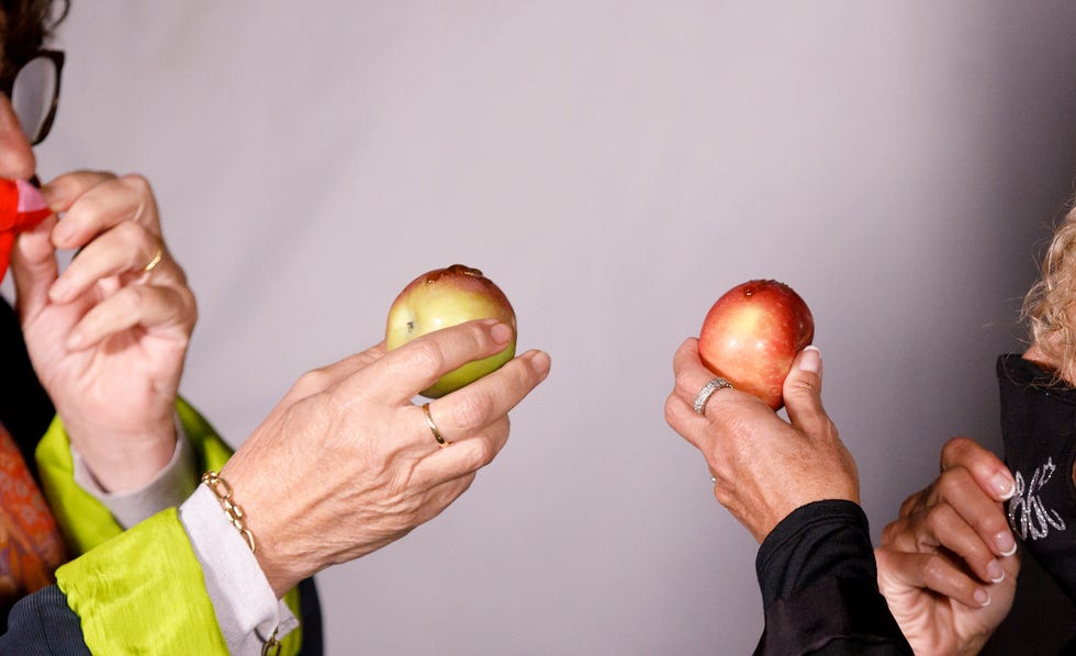 Rabbi Elyse Goldstein, right, and comedian Deb Filler share apples and honey as is customary in Jewish tradition during a socially distanced Rosh Hashanah celebration at a drive-in theater on September 20, 2020 in Toronto.