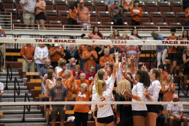 Texas players raise their Hook ❜em signs to fans at the start of their match against Houston on Sept. 15. The No. 1 Longhorns are 10-0 as they head into a Big 12 road match Sunday at Texas Tech.