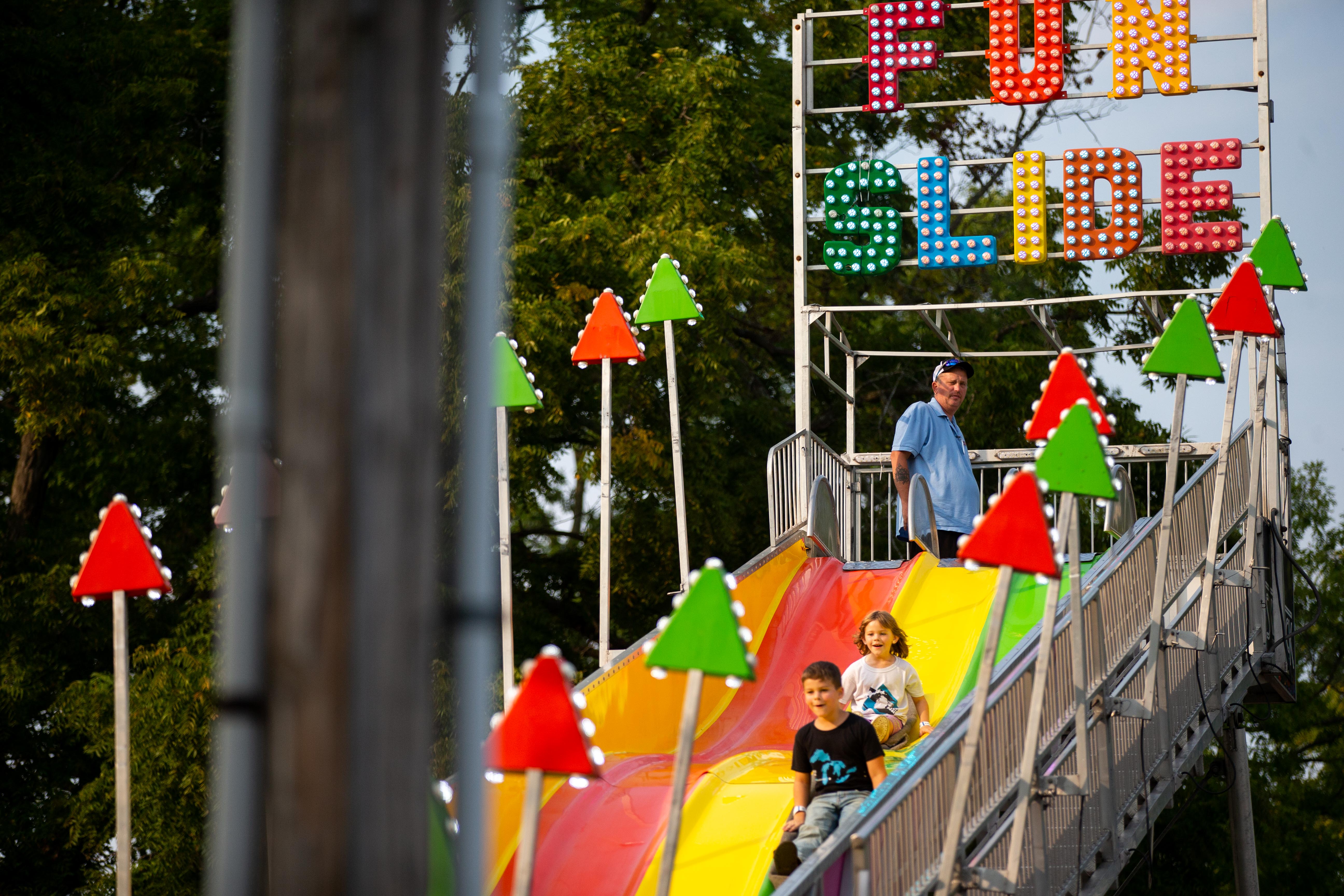 Children slide down the big slide during an evening at the Allegan County Fair on Thursday, Sept. 15, 2022, in Allegan.