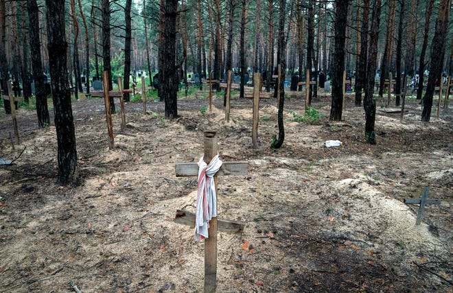 Sebuah pemandangan menunjukkan kuburan tak dikenal dari warga sipil dan tentara Ukraina di sebuah pemakaman, di daerah yang baru-baru ini direbut kembali di Izium, Ukraina, Jumat, 16 September 2022.