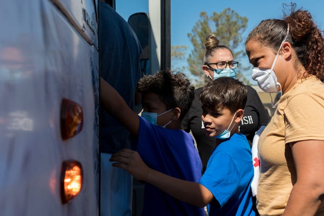 Migrants board a charter bus that will take them to their destination in New York. The city of El Paso and the Office of Emergency Management have set up a Migrant Welcome Center at the COVID Community Center in Northeast El Paso.
