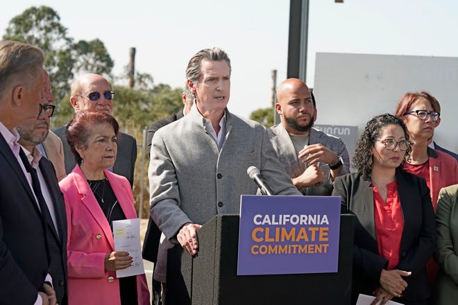 Gov. Gavin Newsom, center, flanked by state lawmakers discusses the package of legislation he signed that accelerates the climate goals of the nation's most populous state, at Mare Island in Vallejo, Calif., Friday, Sept. 16, 2022.