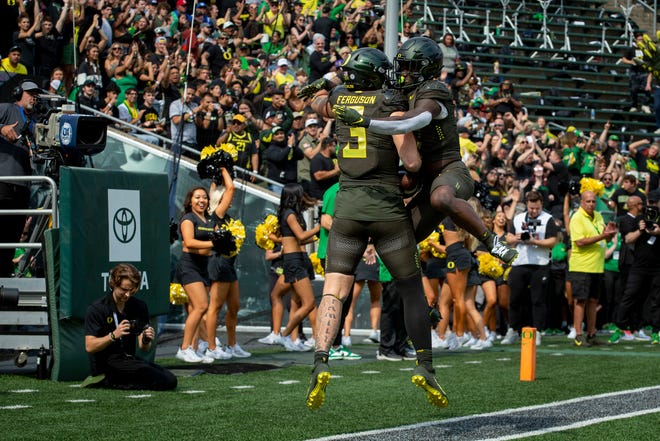 Oregon tight end Terrance Ferguson, left, and running back Sean Dollars celebrate a touchdown catch by Ferguson late in the first half of a game against BYU Saturday, Sept. 17, 2022, at Autzen Stadium. 