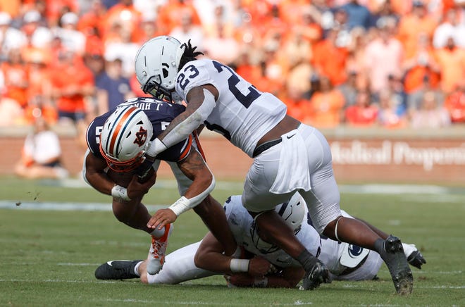 Sep 17, 2022; Auburn, Alabama, USA; Penn State Nittany Lions linebacker Curtis Jacobs (23) tackles Auburn Tigers running back Jarquez Hunter (27) during the first quarter at Jordan-Hare Stadium. Mandatory Credit: John Reed-USA TODAY Sports