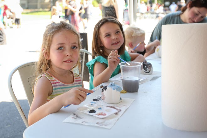 Liberty Spencer, front, and Zoe Buzzard paint pottery pumpkins at the Artistree Pottery tent during Cider Days on Saturday, Sept. 17 along Historic Walnut Street. The two-day fall festival showcases local artisans and craftsmen, food trucks, nonprofits and live entertainment.