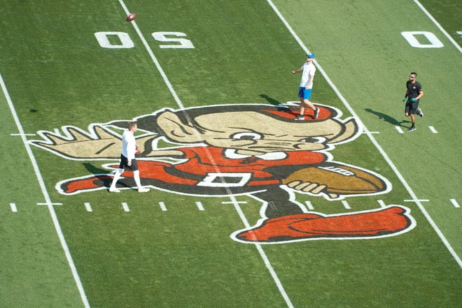 Team members and support people walk over the Cleveland Brownie logo ahead of the Browns home opener, Sept. 18, 2022, vs. the Jets.