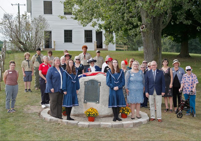 Participants in the ceremony celebrating Lenawee County's bicentennial are pictured Sunday, Sept. 18, 2022, at the Cambridge Junction Historic State Park next to a boulder where the centennial plaque and a new plaque for the bicentennial were unveiled.