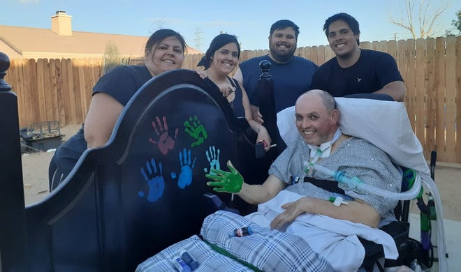 Richard Morrell displays his green-painted hand with his family, which includes, left to right, his wife, Rachael; daughter, Elizabeth and sons, Anthony and Brandon.