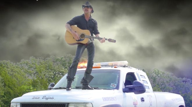 n this screengrab from the music video for "I Saw a Tiger," Joe Exotic stands on top of a pickup.